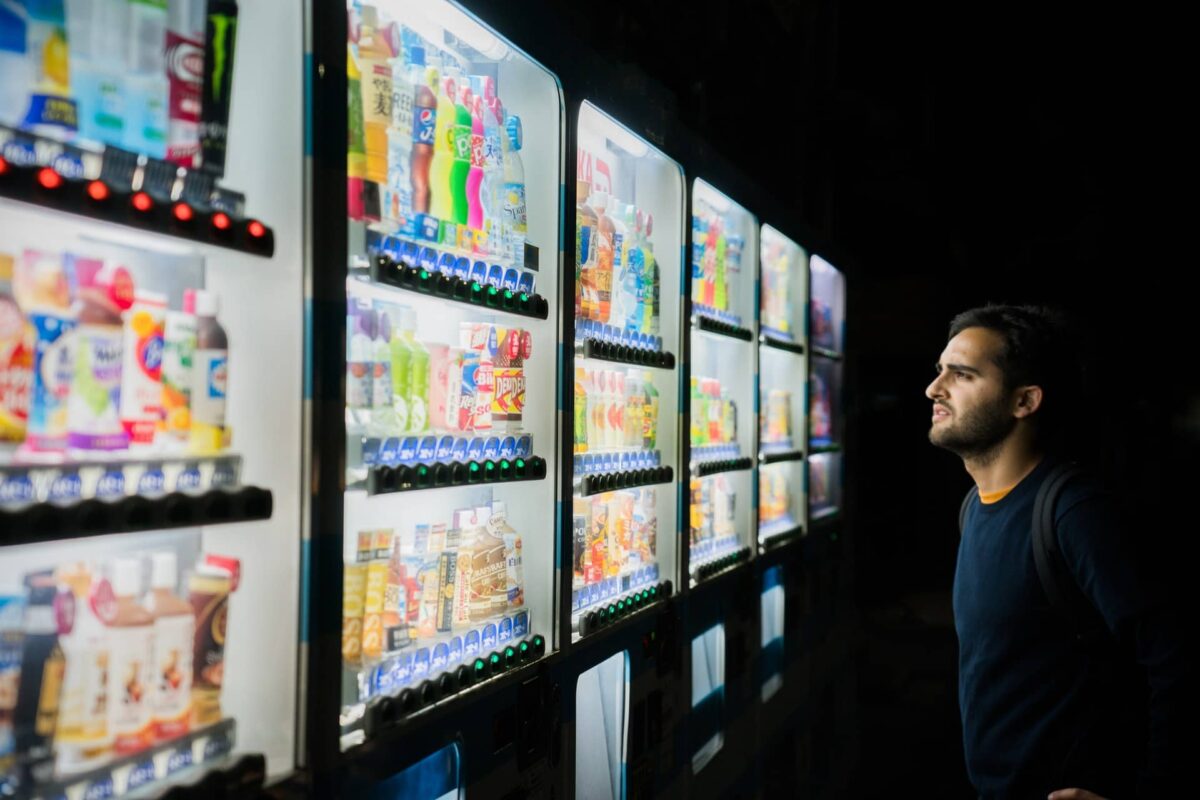 A person standing in front of a vending machine, overwhelmed by a huge variety of options.